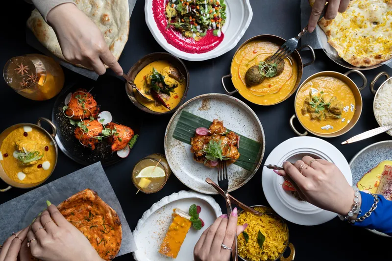 A spread of curries, rice, flatbread and other dishes on a table.