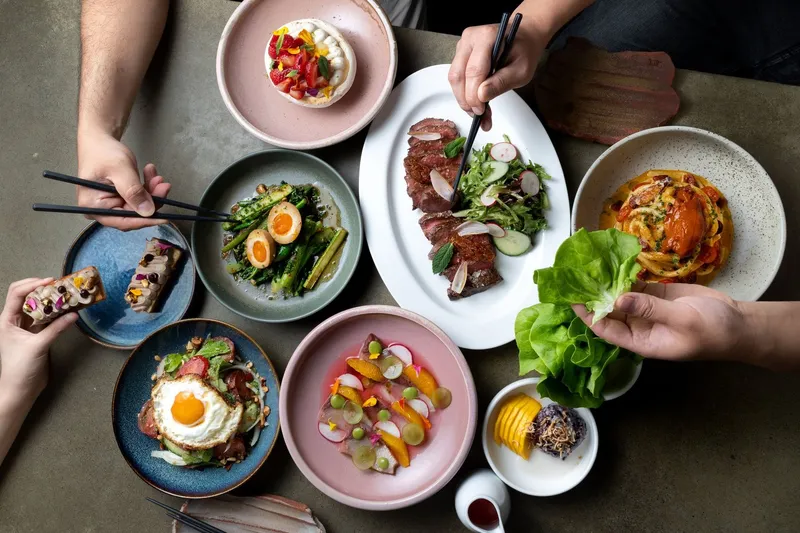 Several plated dishes shared around a restaurant table.