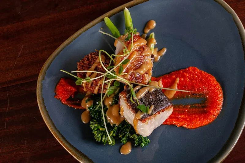A plated dish with vegetables and a bright red sauce.